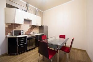 a kitchen with a glass table and red chairs at Lux Apartment on Virmenska 3- with 2 separate bedrooms in Lviv