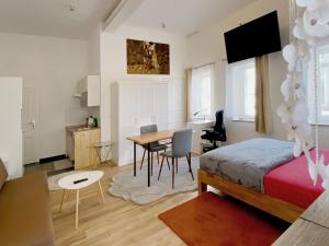 Schlafzimmer mit einem Bett, einem Tisch und Stühlen in der Unterkunft Schwanenburg Apartments in Kolonie Röntgental