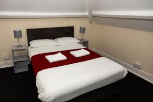 a bedroom with a large bed with two towels on it at AA Sunderland City South in Sunderland