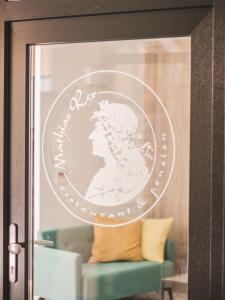 a round coin on a glass door with a couch at Mathias Rex in Szentendre