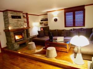 a living room with a couch and a fireplace at Chalet Greystone in Brides-les-Bains