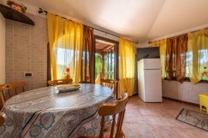 uma cozinha com uma mesa e um frigorífico em Villa Mallus 5 posti letto em Olìa Speciosa