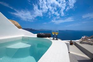 basen z dwoma kieliszkami wina w obiekcie Amaya Castro Villa Caldera View-Outdoor Hot Tub Oia Santorini w mieście Thólos