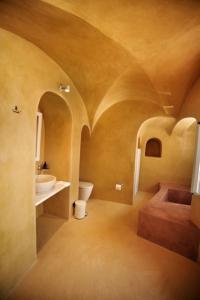 W pokoju znajduje się łazienka z umywalką i toaletą. w obiekcie Amaya Bliss Villa Caldera View-Outdoor Hot Tub Oia Santorini w mieście Thólos