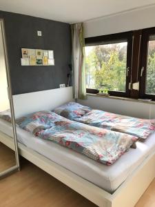 Schlafzimmer mit einem Bett mit einem Spiegel und einem Fenster in der Unterkunft Spechtstraße 65 Ferienwohnung in Nordhorn