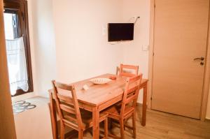 a wooden table and chairs in a room with a television at Lamprou in Kosmas