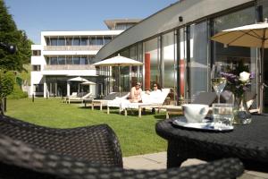 Zwei Personen sitzen auf der Terrasse eines Gebäudes in der Unterkunft Villa Seilern Vital Resort in Bad Ischl