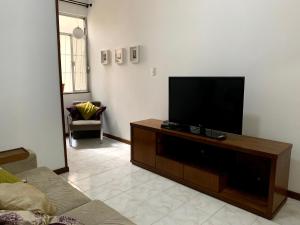 a living room with a flat screen tv on a wooden entertainment center at Apartamento Copacabana Praia, Metrô e Wi-fi Alta Velocidade in Rio de Janeiro