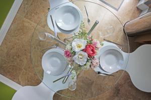 a table with plates and a vase of flowers on it at Queens Road - Luxury Spacious Home in Chester in Christleton
