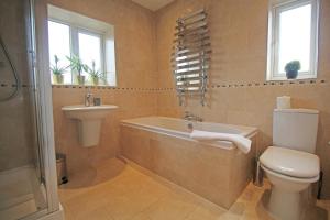 ein Badezimmer mit einer Badewanne, einem WC und einem Waschbecken in der Unterkunft Queens Road - Luxury Spacious Home in Chester in Christleton