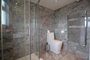 a bathroom with a toilet and a glass shower at Queens Road - Luxury Spacious Home in Chester in Christleton +57 photos
