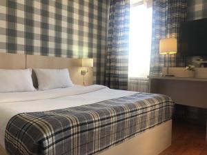 a bedroom with a bed with a checkered wall at Dublin Hotel in Novorossiysk