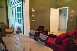 sala de estar con mesa y sofá rojo en Sky Nautico Apartment, en São Tomé