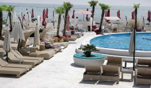 een resort met stoelen en een zwembad en de oceaan bij Arcadijskiy Palace in Odessa