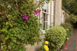 a garden filled with flowers next to a window at Bankton House in Livingston