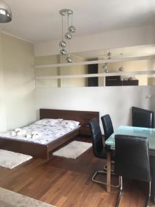 Habitación con cama, mesa y sillas. en apartament centrum, en Gdynia