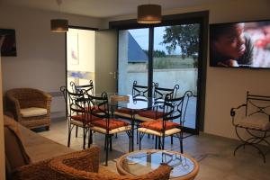 d'une salle à manger avec une table, des chaises et une fenêtre. dans l'établissement LOGIS DU GRAND PIN, à Bayeux