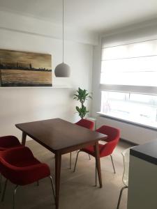 a dining room with a table and red chairs at Appartement op top locatie in Antwerpen in Antwerp