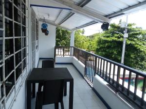 a balcony of a house with a table and chairs at Marysol Lodging in San Andrés