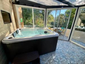 bañera grande en una habitación con ventanas en suite phantastica en Les-Pennes-Mirabeau
