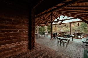 a room with tables and chairs in a wooden building at Cabana La Panţiru in Văleni-Stînişoara