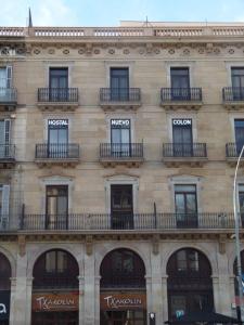 バルセロナにあるオスタル ヌエボ コロンの窓とバルコニー付きの建物です。