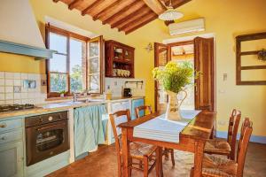 a kitchen with a table with a vase of flowers on it at Podere Lamino in Monticchiello