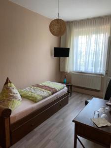 a bedroom with a bed and a living room with a table at Pension No. 55 in Erfurt