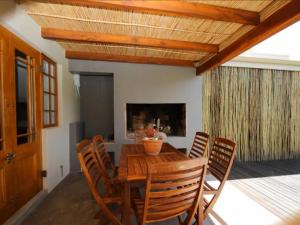 uma sala de jantar com uma mesa de madeira e cadeiras em New Beginnings Cottage em Montagu
