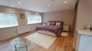 a room with a bed, table and a window at The Garden Room, 1 Heath Cottage in Knutsford