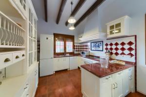 een grote keuken met witte kasten en een houten vloer bij Holidays2Malaga Candado House pool & garden in Málaga