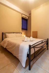 een slaapkamer met een groot bed met witte lakens en een raam bij Kountouriotou New Quiet and Central apartment in Athene