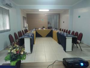 Hotel Tauari في مارابا: قاعة اجتماعات مع طاولة وكراسي طويلة