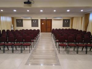 Habitación vacía con sillas rojas y puerta de madera en Hotel Tauari, en Marabá