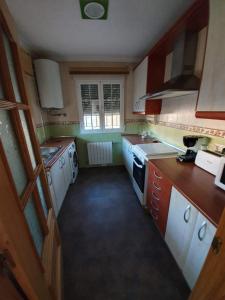 una pequeña cocina con electrodomésticos blancos y una ventana en Chalet Las Praderas, en Chillarón de Cuenca