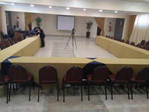 Hotel Tauari في مارابا: قاعة اجتماعات مع طاولة وكراسي وشاشة