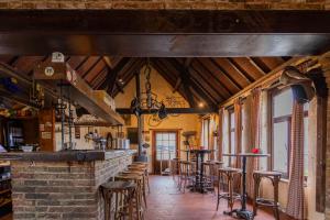 a bar with tables and stools in a room at Hoeve De Blauwe Zaal in Bruges