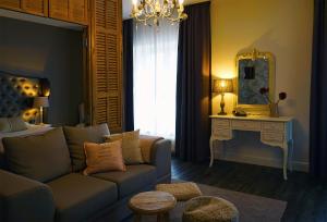 a living room with a couch and a mirror at Abdij Hotel Rolduc in Kerkrade
