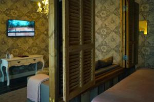 a bedroom with a bed and a table with a tv at Abdij Hotel Rolduc in Kerkrade