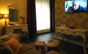 a living room with a couch and a tv on the wall at Abdij Hotel Rolduc in Kerkrade