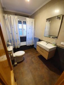 a bathroom with a sink and a toilet and a mirror at Chalet Las Praderas in Chillarón de Cuenca