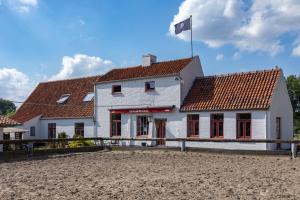 a white house with a flag on top of it at Hoeve De Blauwe Zaal in Bruges