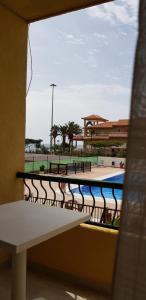 a balcony with a bench and a swimming pool at PLAYA LAS VISTAS LOFT in Los Cristianos