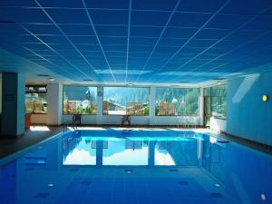 a large swimming pool with a blue ceiling at Hotel Principe Marmolada in Malga Ciapela