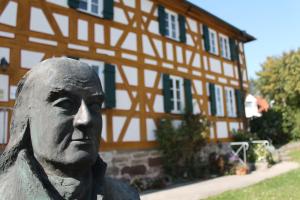 a statue of a man in front of a building at Pension Pastoriushaus in Bad Windsheim