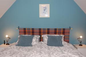 a bedroom with a bed with two pillows at Donmar Cottage in Skeabost