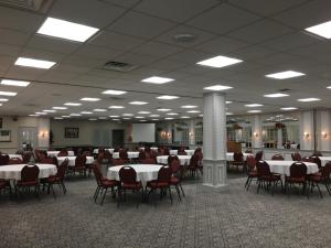 a banquet hall with white tables and red chairs at 1863 Inn of Gettysburg in Gettysburg
