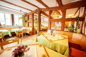 a restaurant with tables and chairs and wooden ceilings at Pension Pastoriushaus in Bad Windsheim