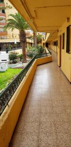 an empty hallway of a building with palm trees at PLAYA LAS VISTAS LOFT in Los Cristianos