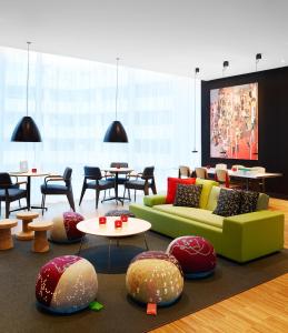 a living room with couches and tables and chairs at citizenM Rotterdam in Rotterdam